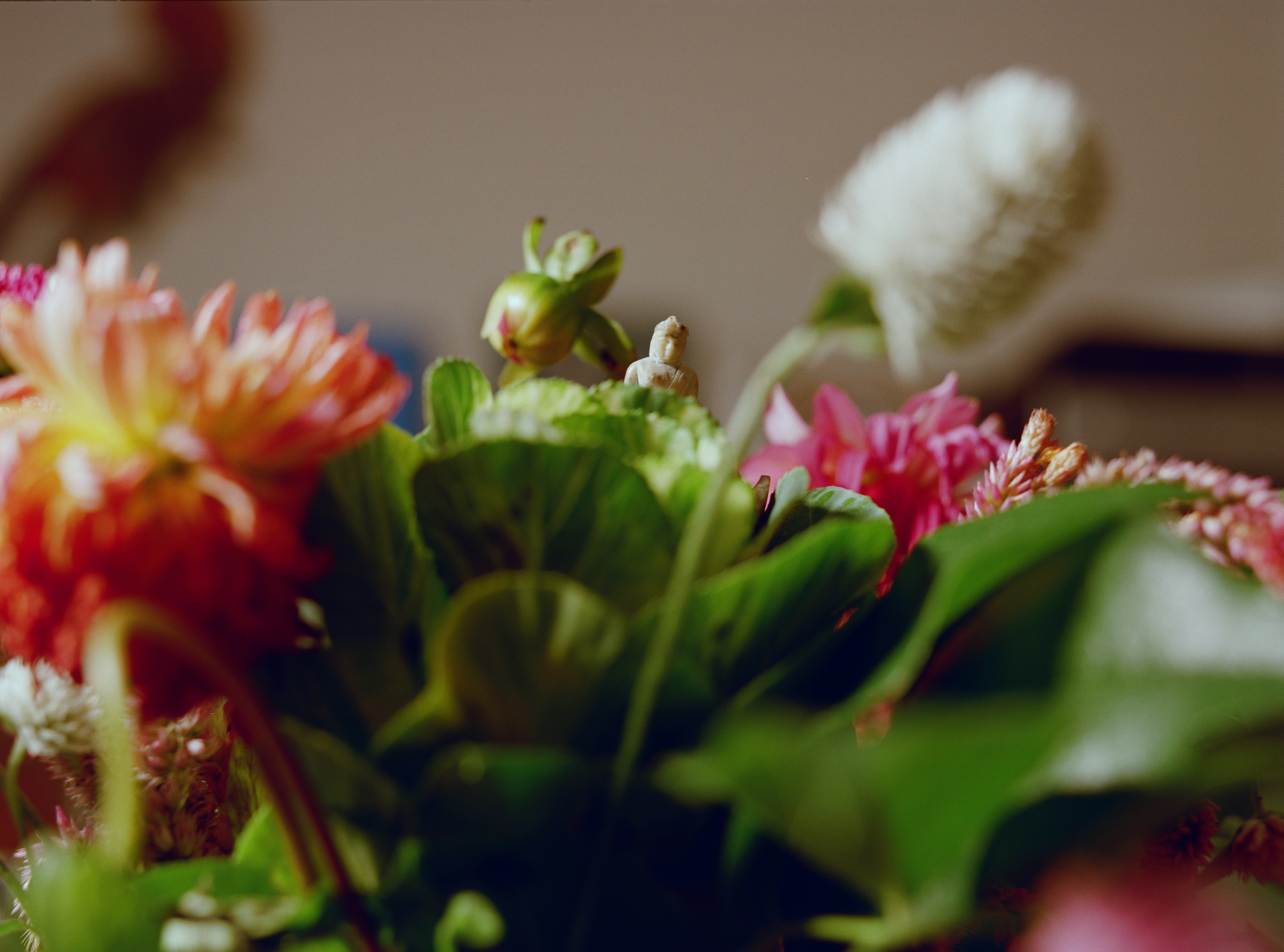 Small ceramic Buddha amidst flowers